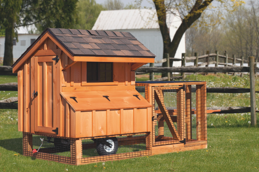 wooden tractor chicken coop with attached run and wheels and shingle roof