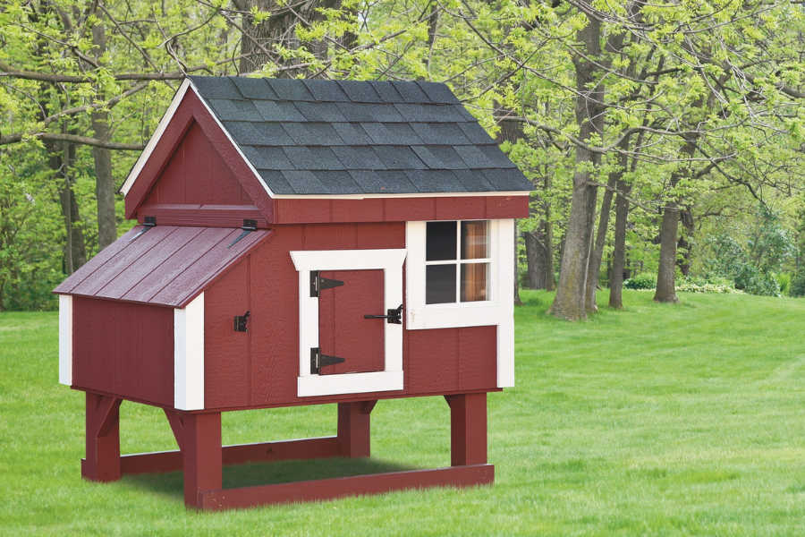 red and white trimmed a frame coop with gray shingle roof slightly raised off ground