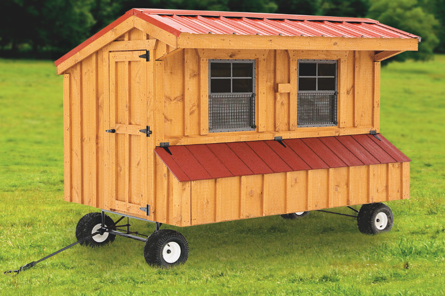 small wooden quaker chicken coop with red metal roofing and lid on egg collection boxes featuring wheels a side door and a handle plus two front windows