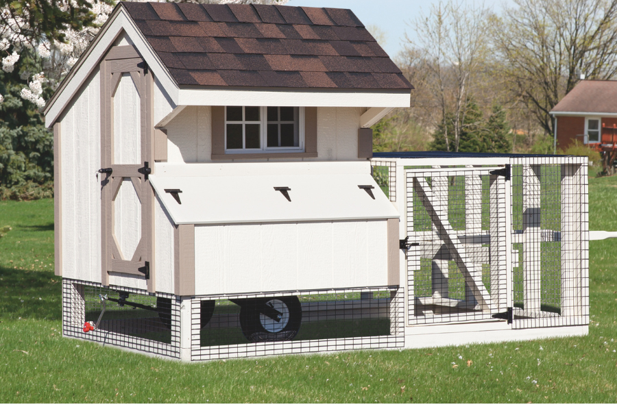 white and tan trimmed tractor chicken coop with attached run one egg collection box and window and wheels