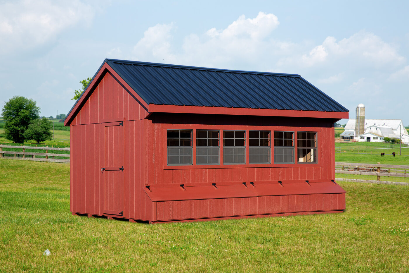 red quaker coop with black metal roof 6 windows and egg collection boxes underneath