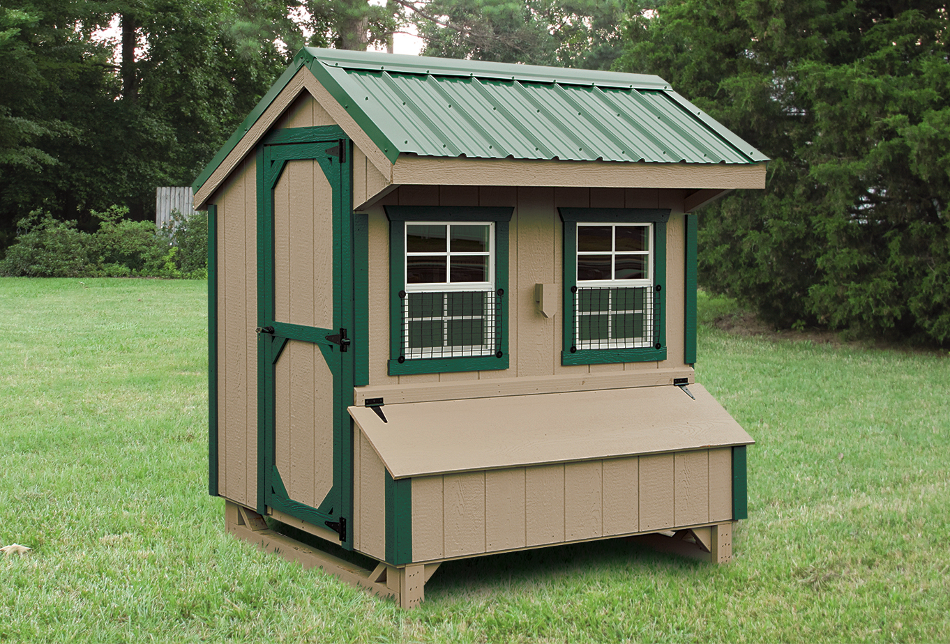dark tan quaker coop with green trim and roof two windows in front and an egg collection basket