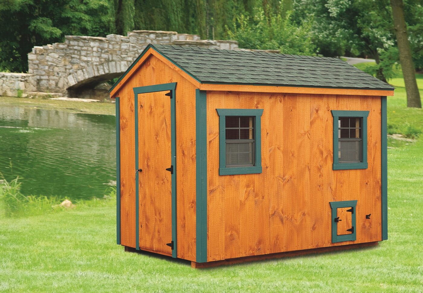 wooden a frame chicken coop with dark green trim and shingle roof