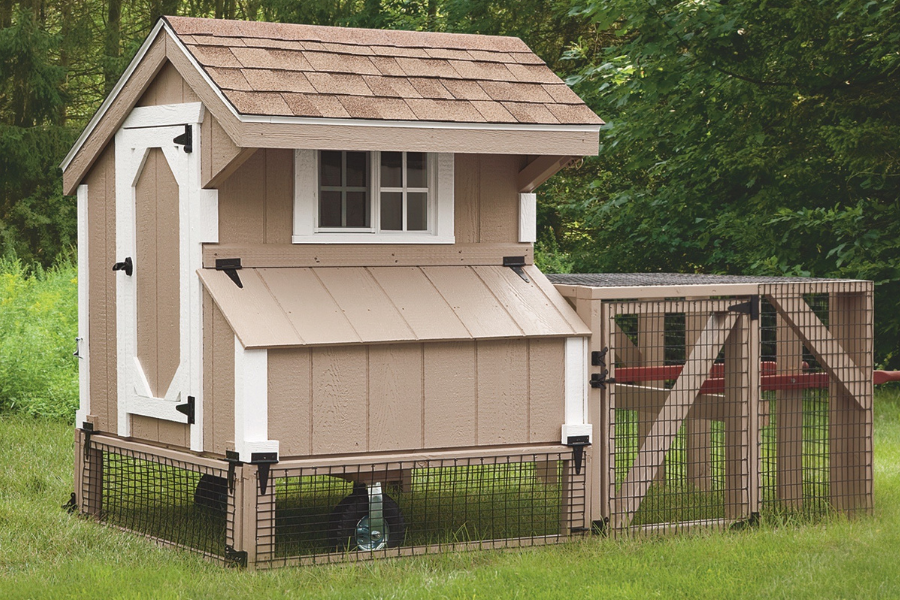 tan tractor chicken coop with white trim shingle roof wheels and an attached run with reddish wooden handles