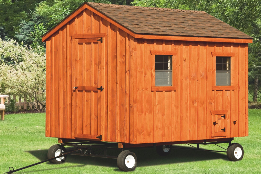 wooden a frame coop with two windows side door wheels handle and a shingle roof