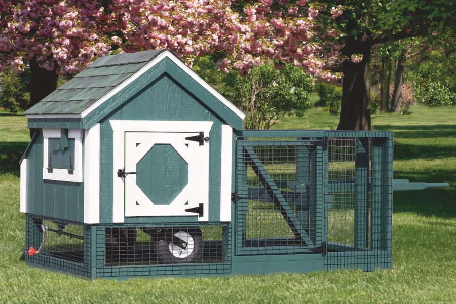 green tractor chicken coop with white trim wheels and attached run