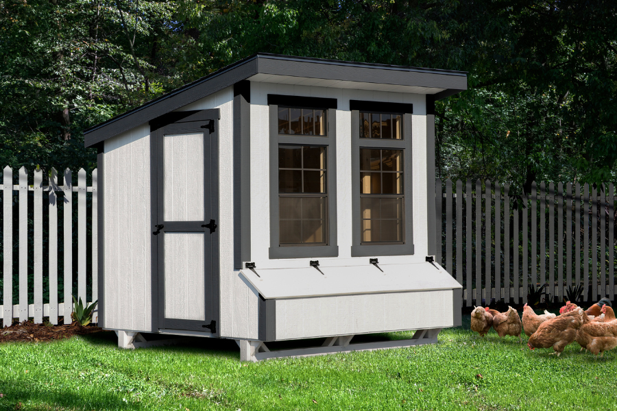 white and black trimmed lean to coop with two large windows and an egg collection box
