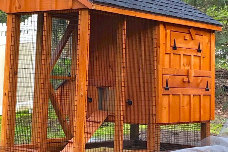 close up of attached run on wooden chicken coop with shingle roof