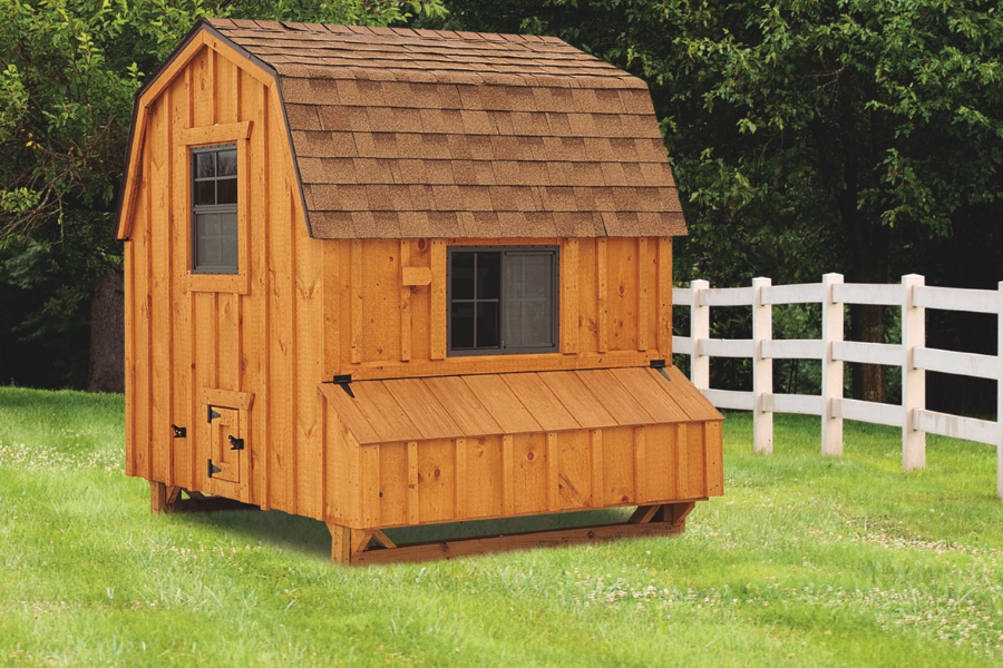 wooden barn style chicken coop with shingle roof