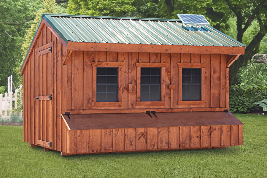 wooden quaker chicken coop with green metal roof and solar panel in San Antonio TX