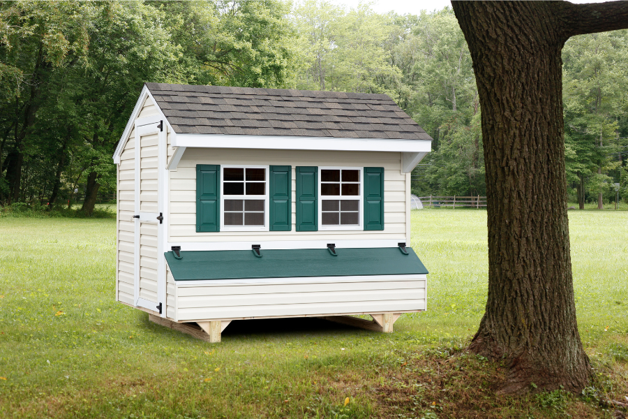white vinyl chicken coops in Texas with green shutters and lid on egg collection box