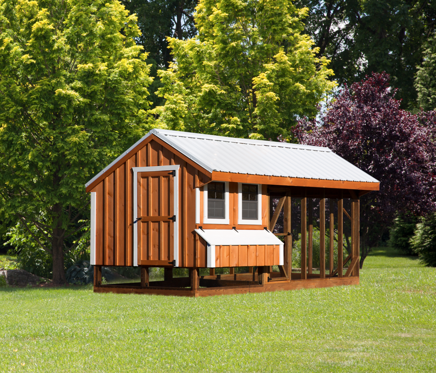 A beautiful combination chicken coop with board & batt siding and white trim in Utah.