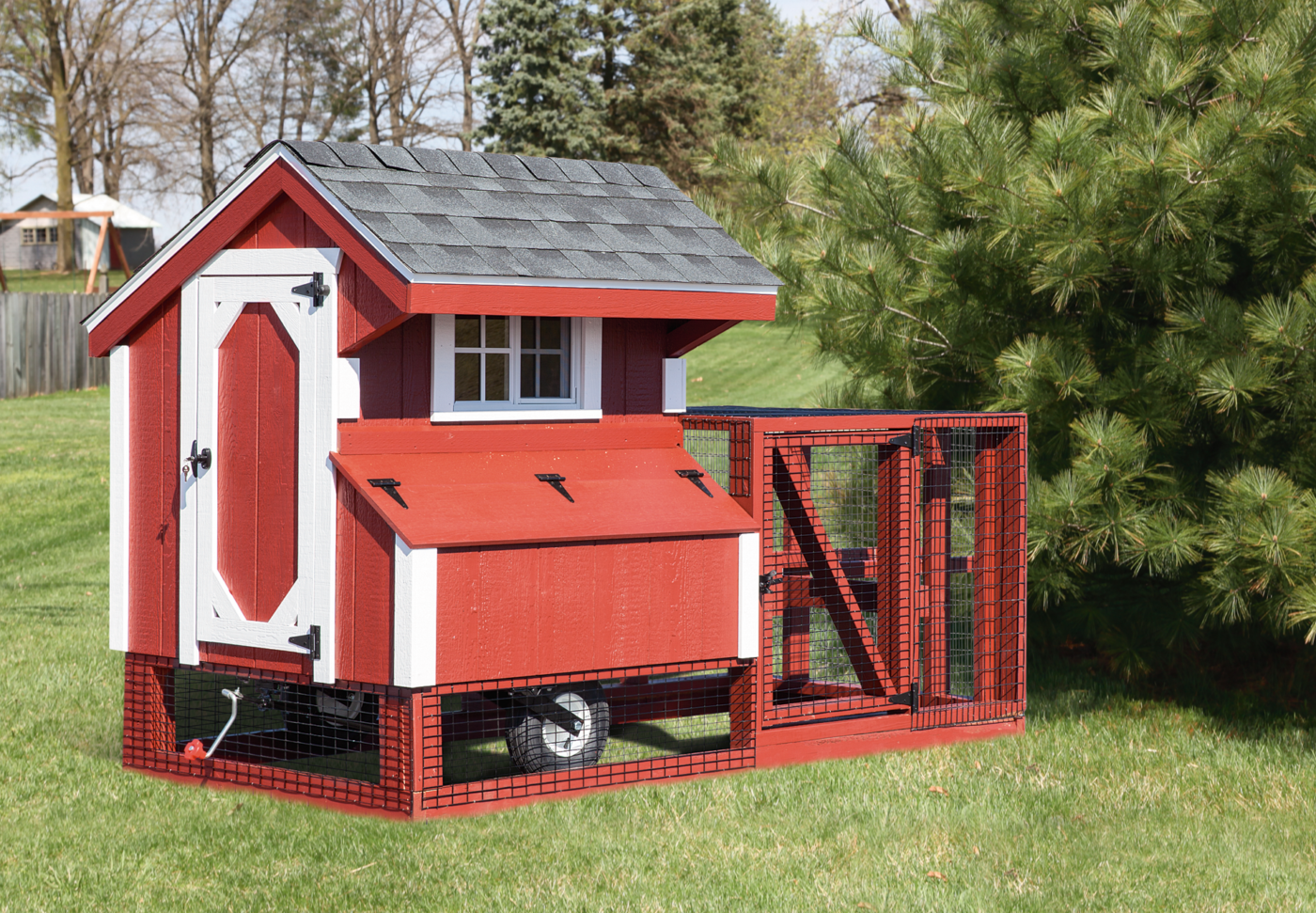 A Red Tractor Chicken Coop with wheels and white trim in a Utah backyard.