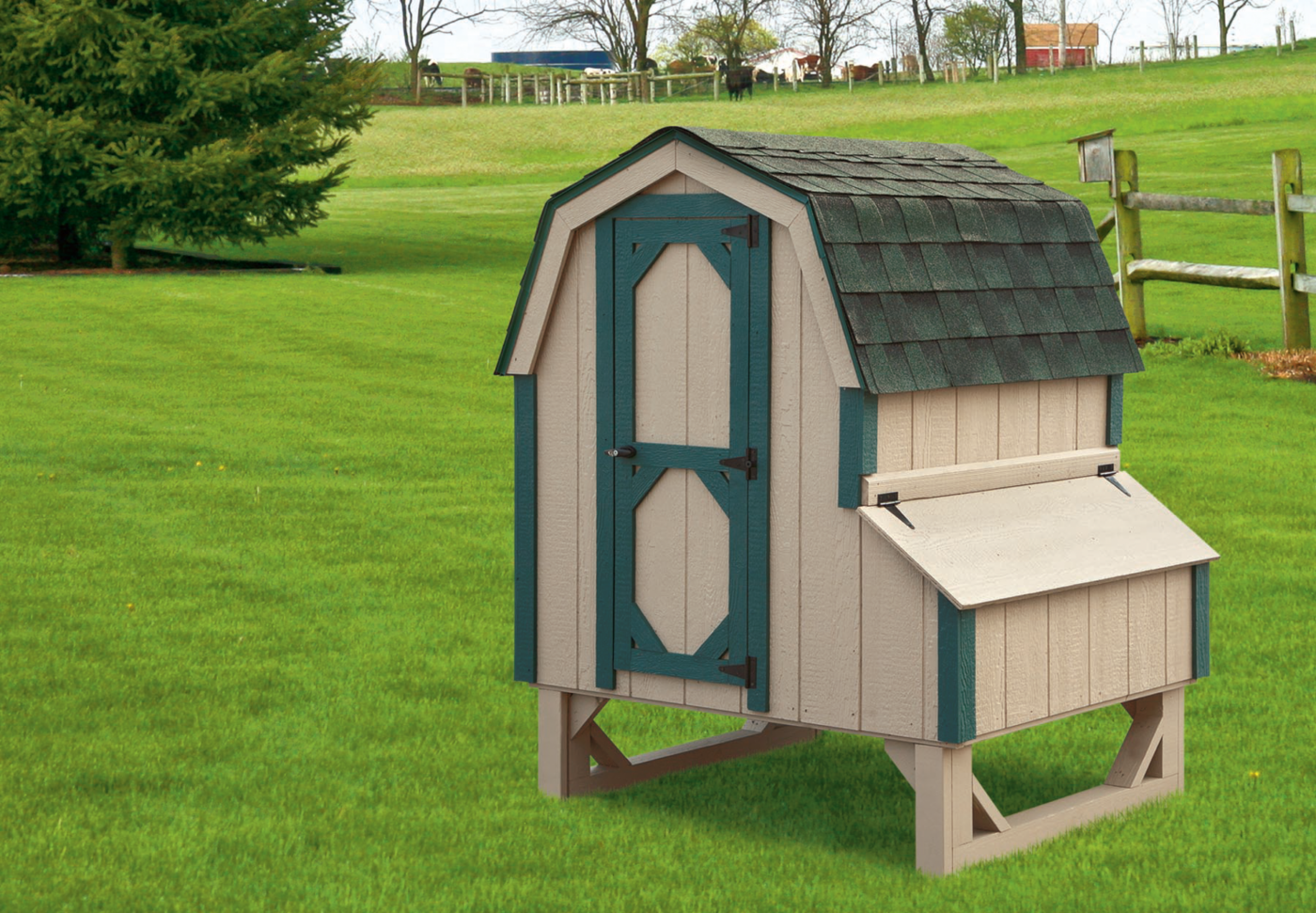 A tan chicken coop with a gambrel roof and green trim in a green Salt Lake City backyard.