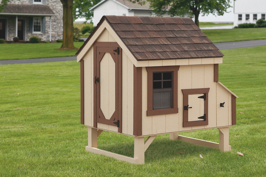 tan A frame chicken coop with dark brown trim raised off ground