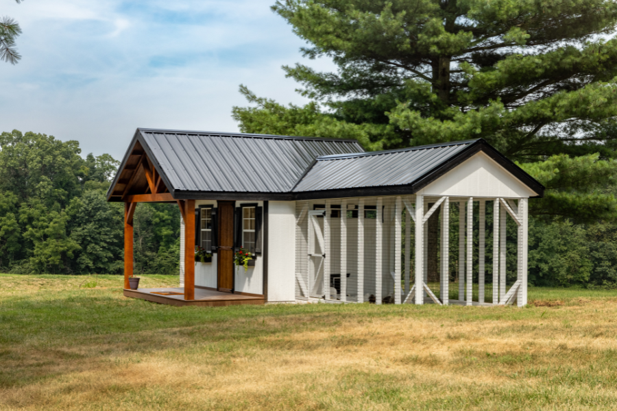 side view of white combination coop with attached run black metal roof and front porch
