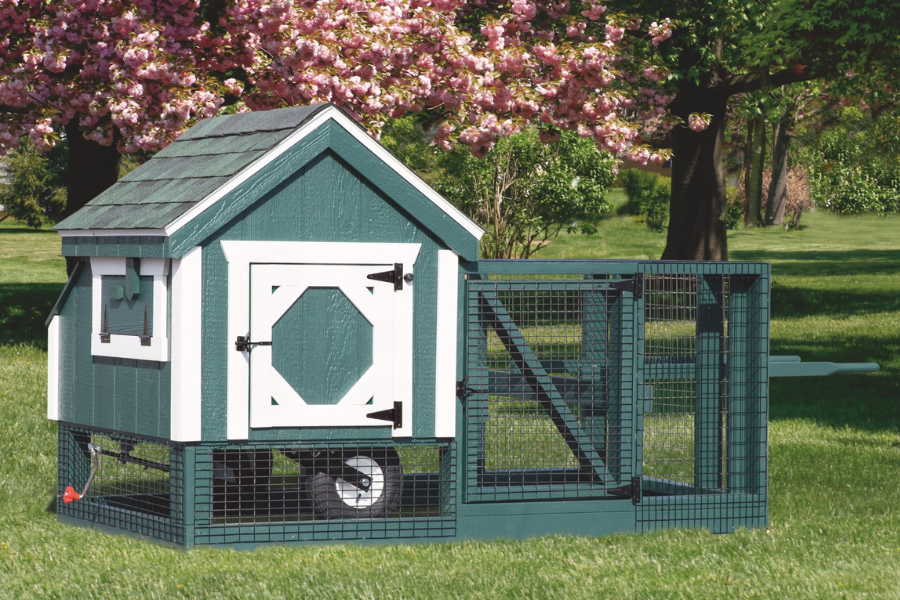 green and white trimmed tractor chicken coop with wheels handle and an attached run plus greenish shingle roof