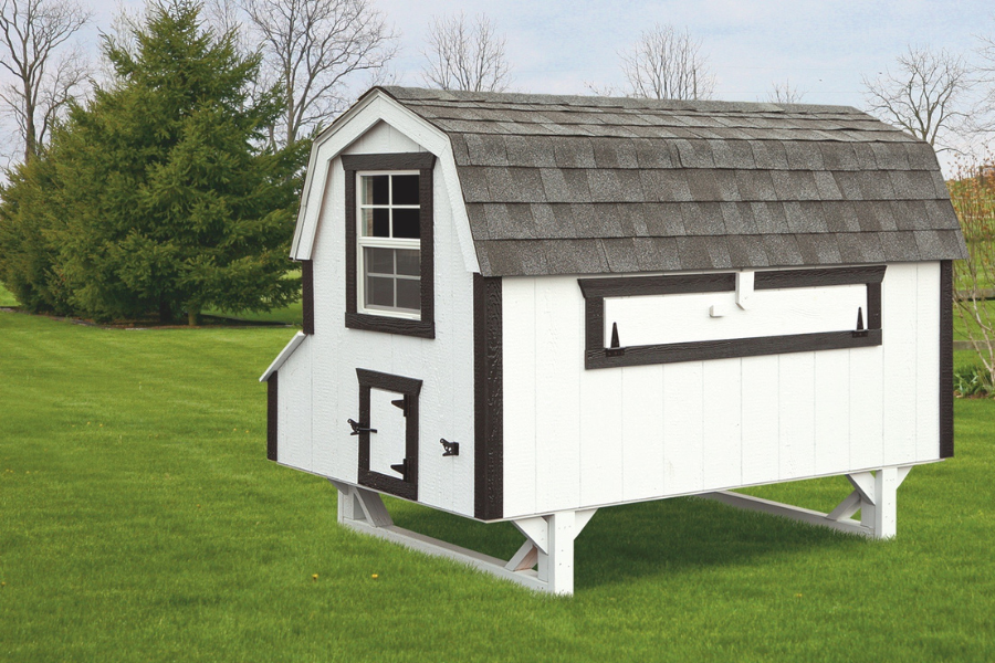 white and black trimmed dutch coop raised off ground with curved gray shingle roof in Cheyenne WY backyard