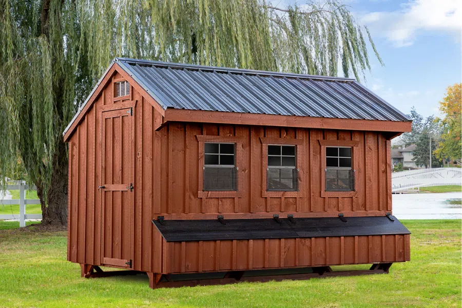 wooden quaker chicken coop with black metal roof and black lids on egg collection boxes