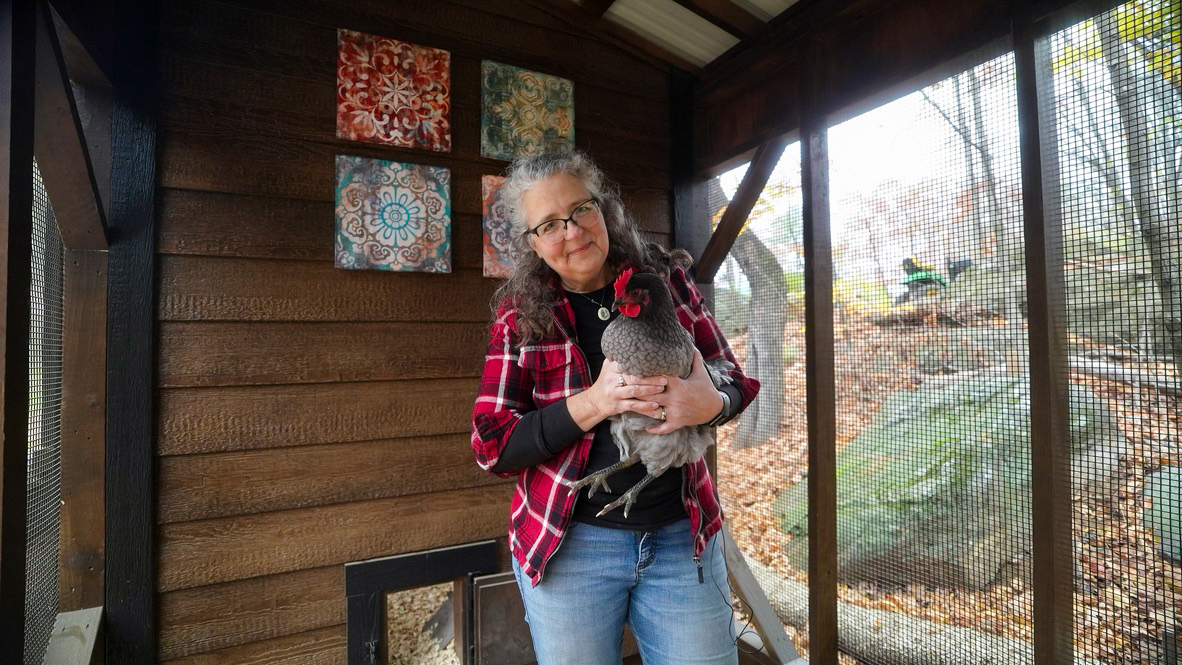 Michelle Visser holding a chicken in her 7x28 Lean-To Combination Coop in NH