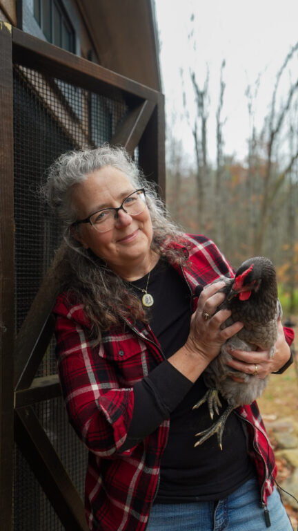 Michelle Visser holding one of her chickens in front of her new 7x28 Chicken Coop