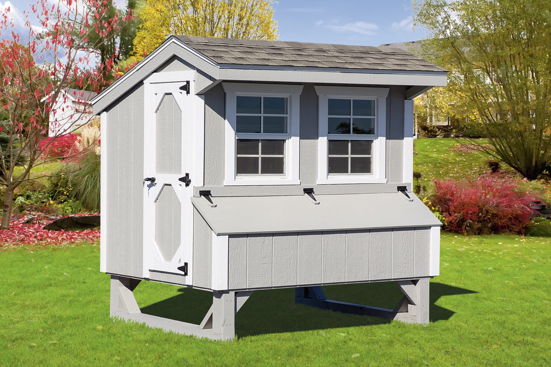 gray quaker chicken coop with white trim and an egg collection box below two windows on the front