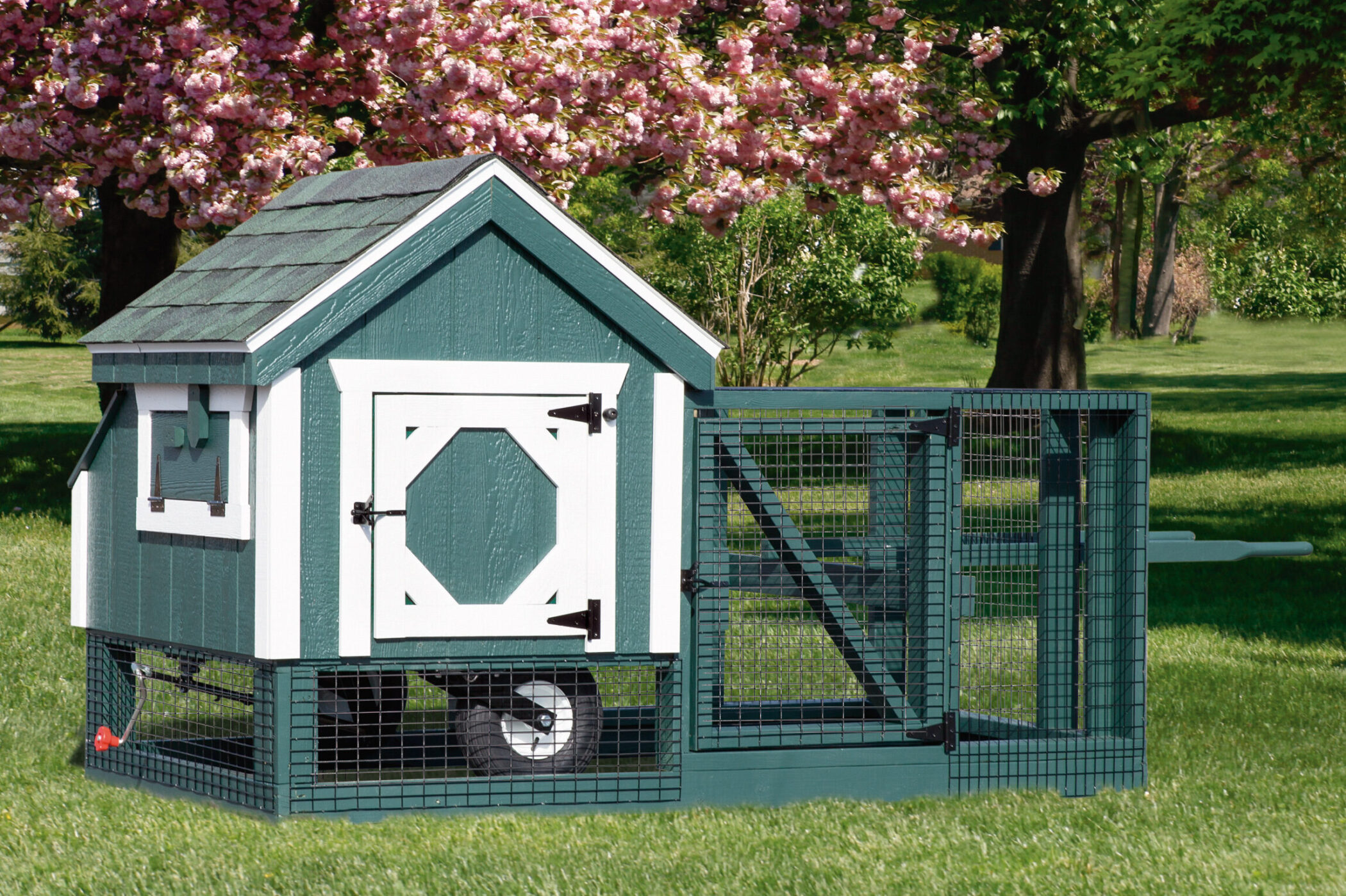 green tractor coop with white trim wheels and outdoor run
