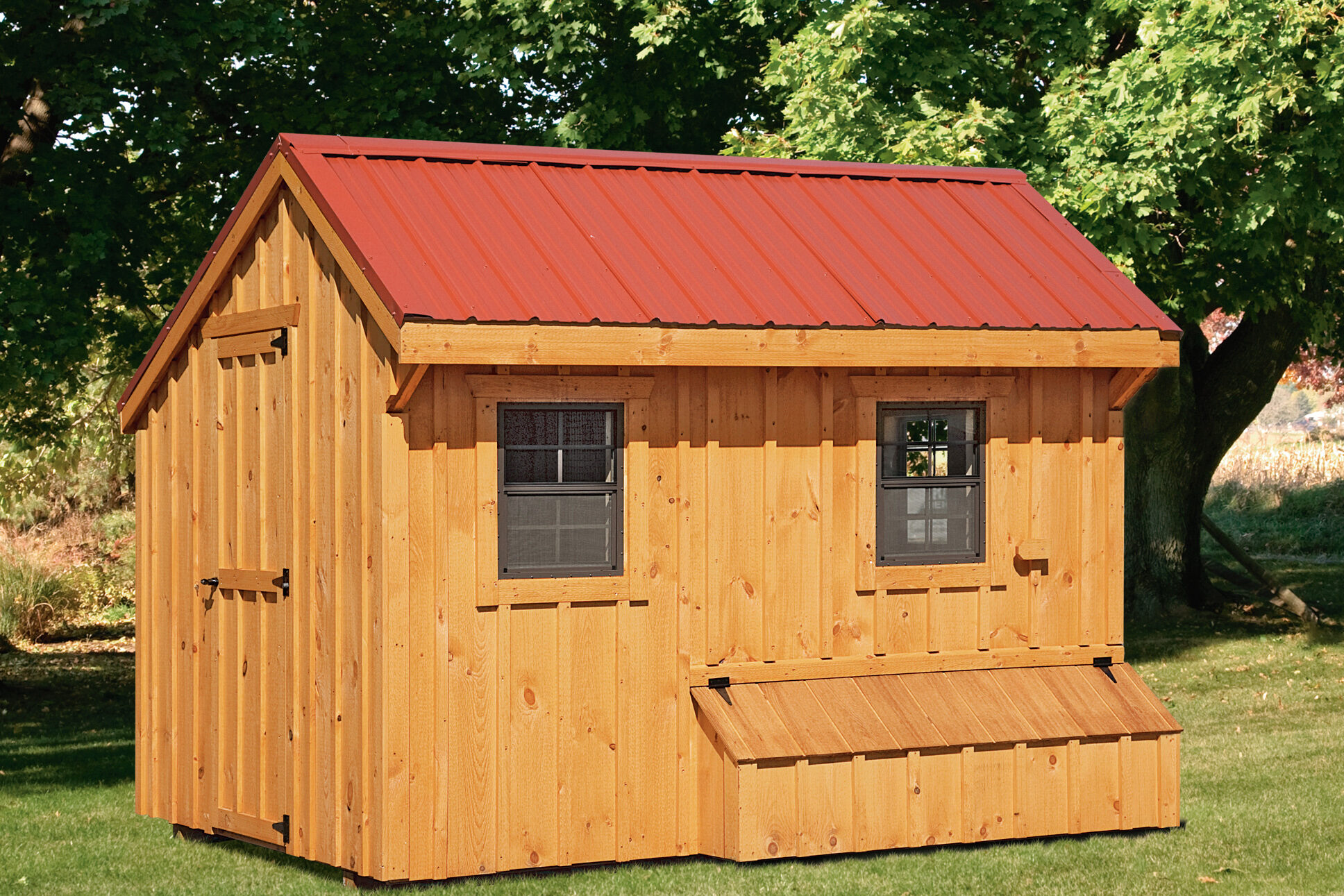 wooden lean to coop with red metal roof two black windows and an egg collection box under one window